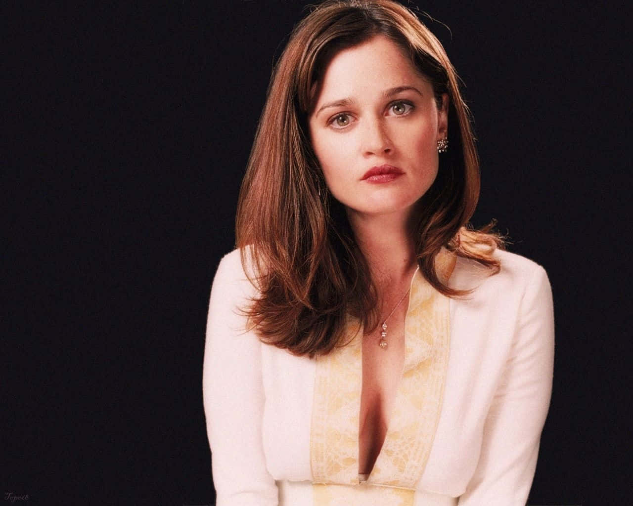 Robin Tunney 桌布 壁紙 — 一位棕色頭髮、綠色眼睛的女性，在黑色背景前穿著白色西裝外套，內搭黃色蕾絲上衣。