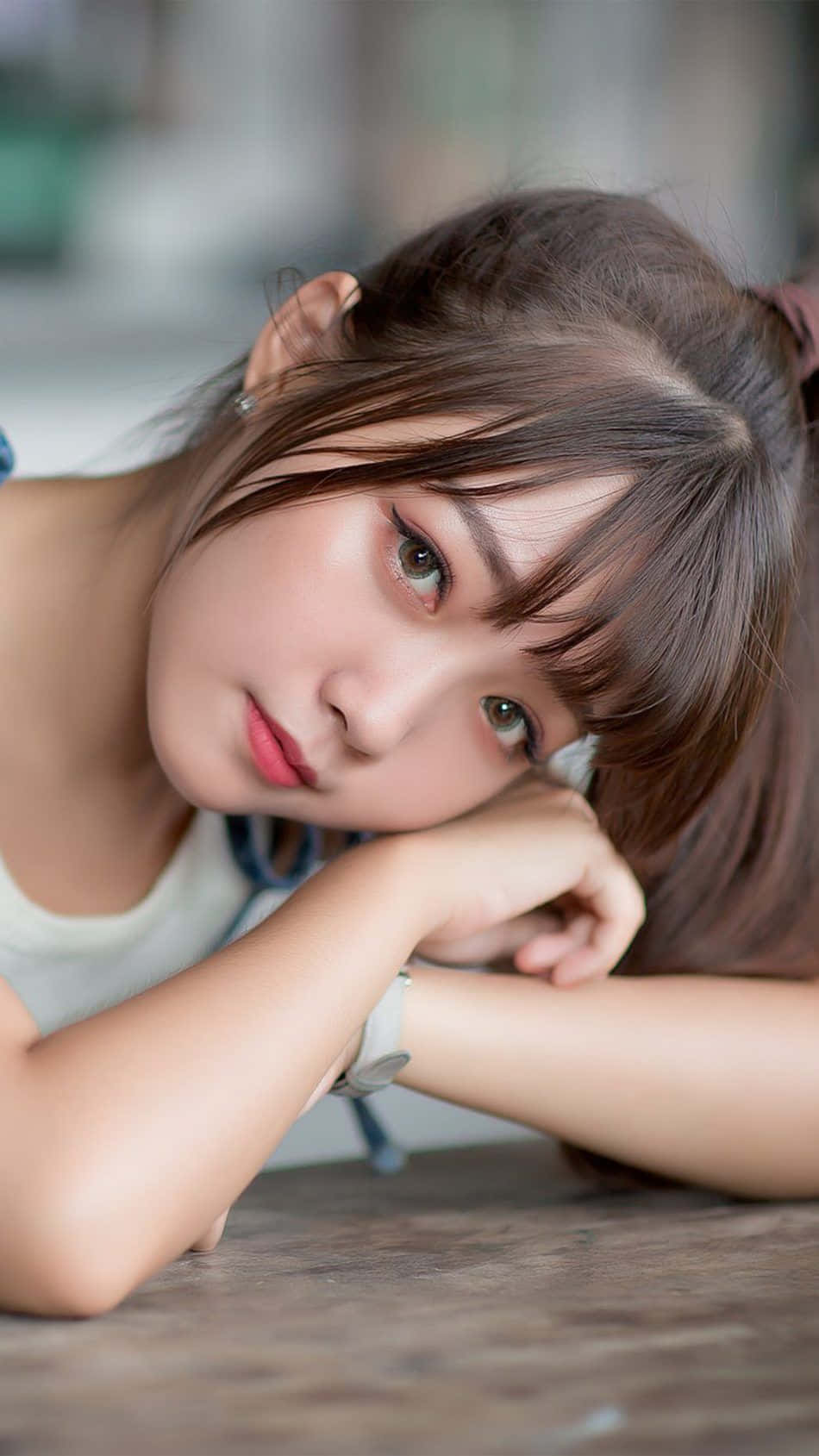 美女 桌布 壁紙 — 一位棕色頭髮的年輕女子將下巴擱在手上，溫柔地凝視著鏡頭。