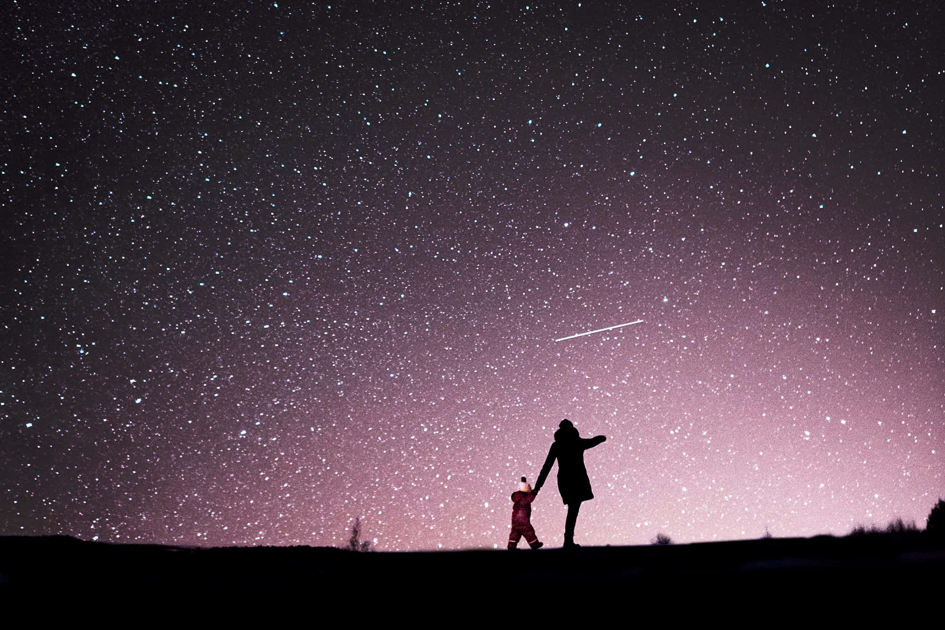 Stars 桌布 壁紙 — 一位母親和孩子的剪影手牽手站在廣闊的星空下，一顆流星劃過頭頂。