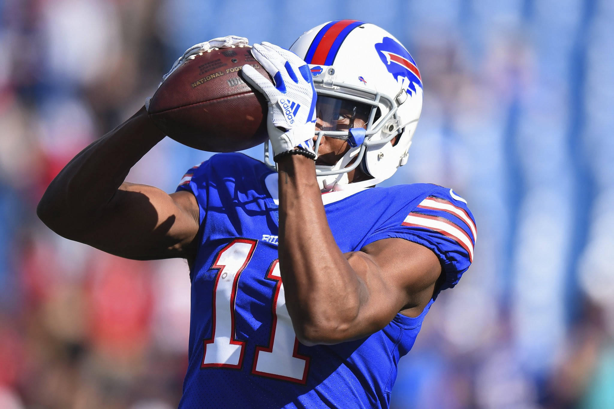 zay jones 桌布 壁紙 — 一位水牛城比爾隊的美式足球員身穿藍色11號球衣，在陽光明媚的比賽中用雙手接住一個足球。