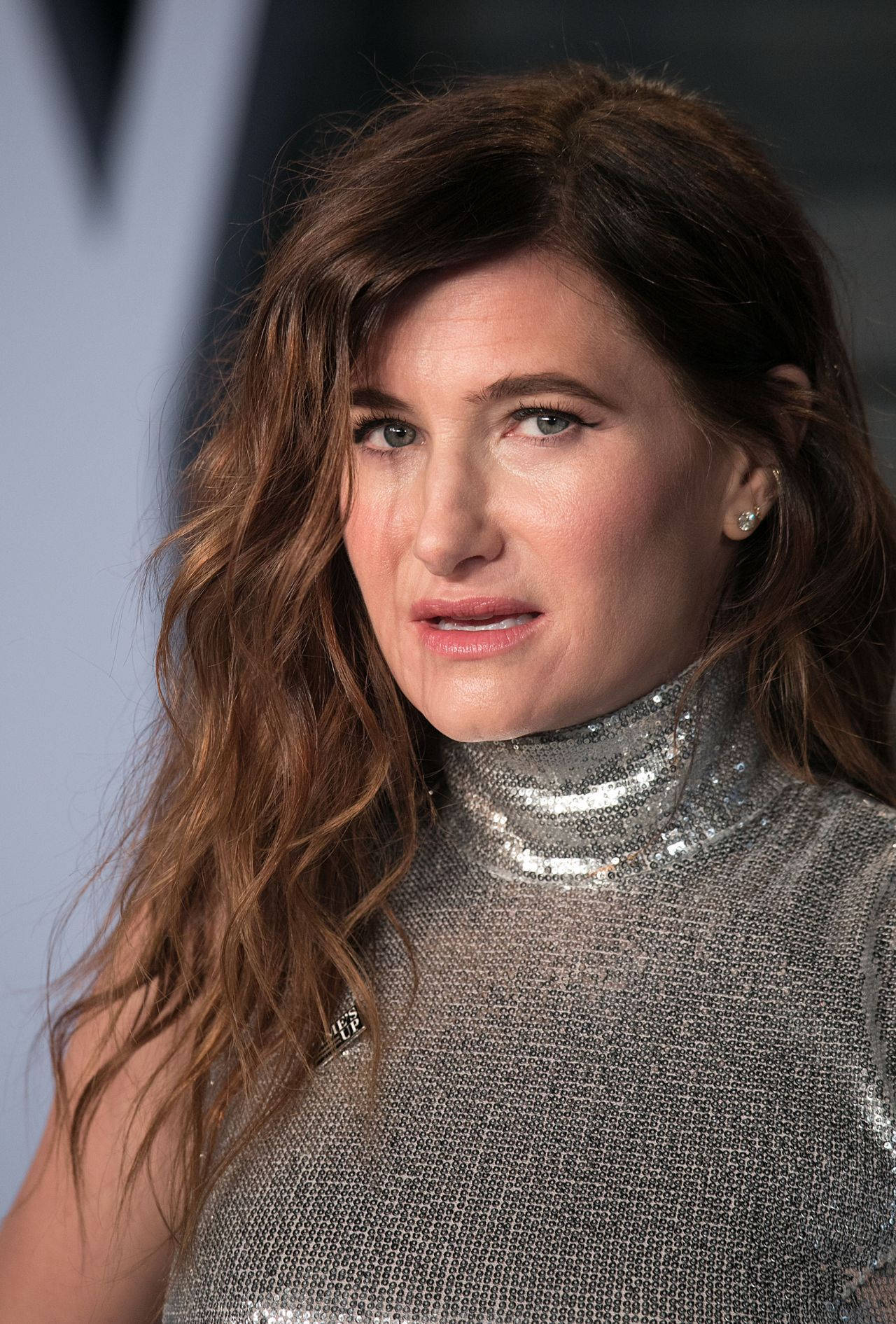 Celebrity 桌布 壁紙 — 一位波浪棕色頭髮的女性在活動中穿著閃爍銀色亮片高領毛衣的特寫肖像。