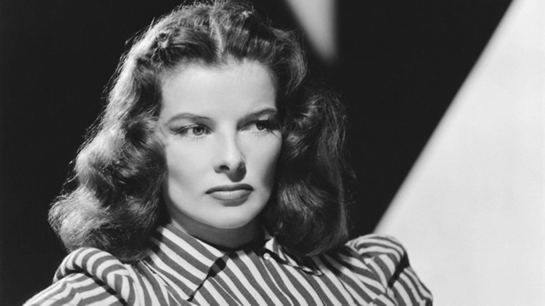 Celebrity 桌布 壁紙 — 一位波浪長髮、身穿條紋襯衫的女性，在鮮明的幾何背景前的黑白肖像。