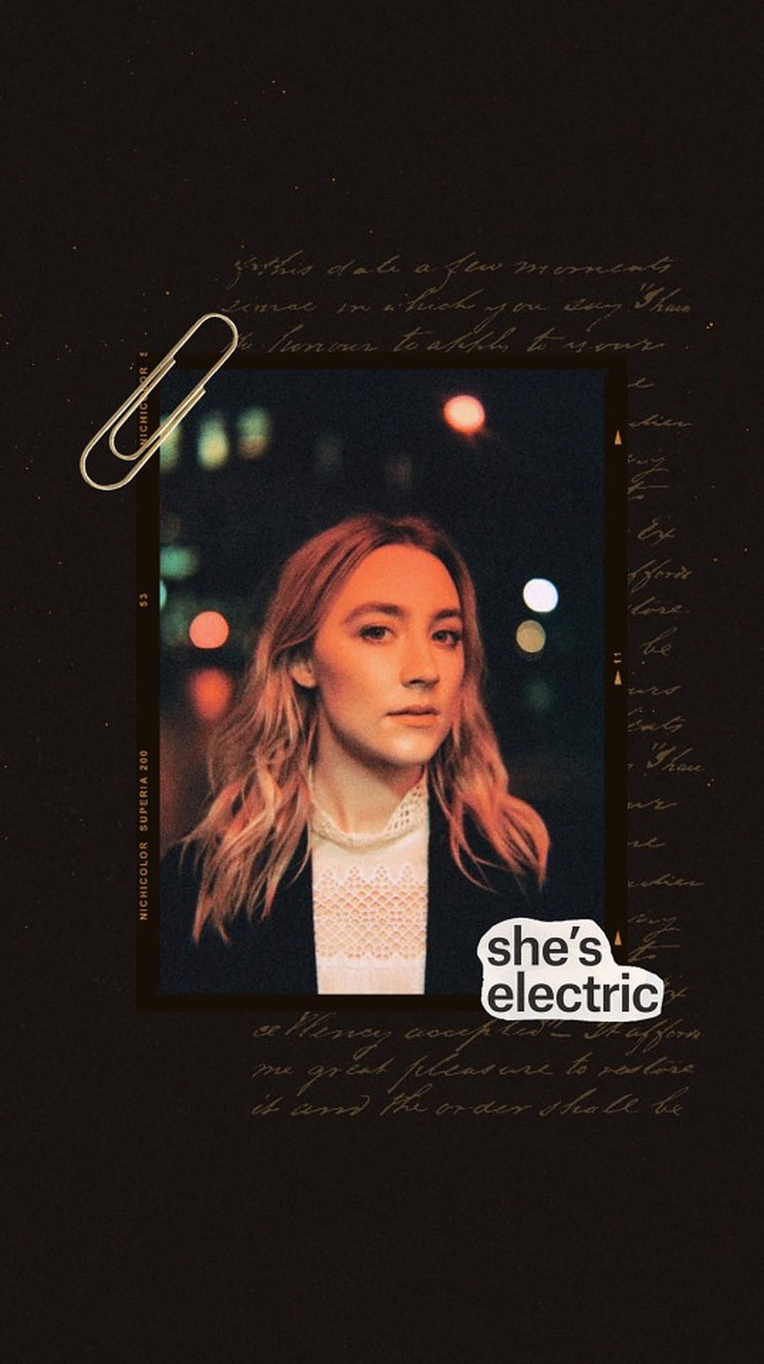 Saoirse Ronan 桌布 壁紙 — 一位波浪長髮的女性在模糊的城市夜景背景中向前凝視，背景有散景燈光，一個迴紋針夾著一個復古相框。