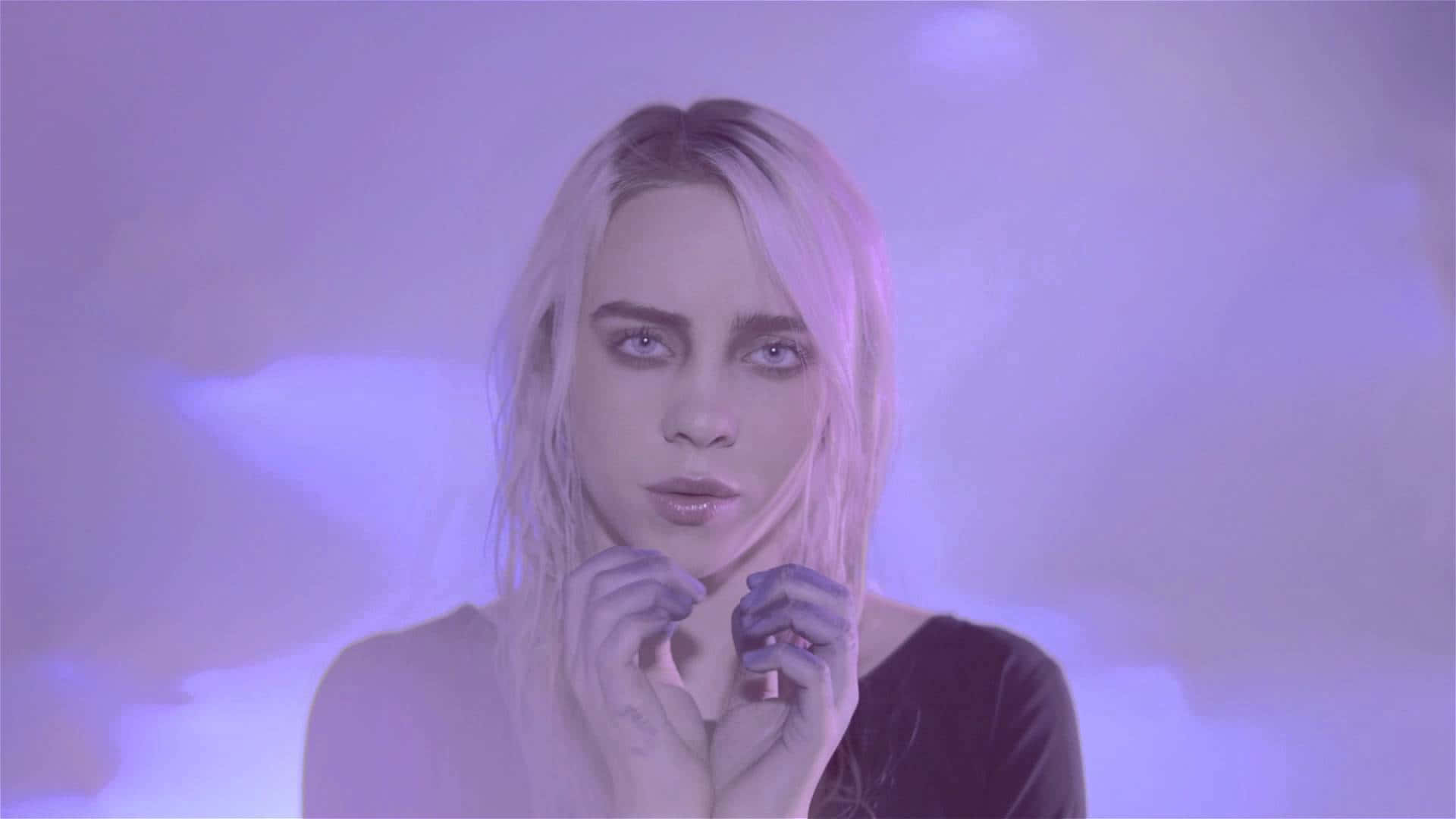Billie Eilish Purple 桌布 壁紙 — 一位淡金色頭髮的女性在朦朧的紫色背景中，伴隨著柔和發光的雲朵，凝視著。