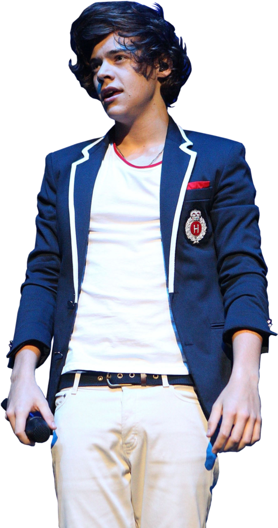 Singer 桌布 壁紙 — 一位深色捲髮的年輕男子在舞台上表演，身穿海軍藍鑲白邊的西裝外套，內搭白色T恤和米色長褲。