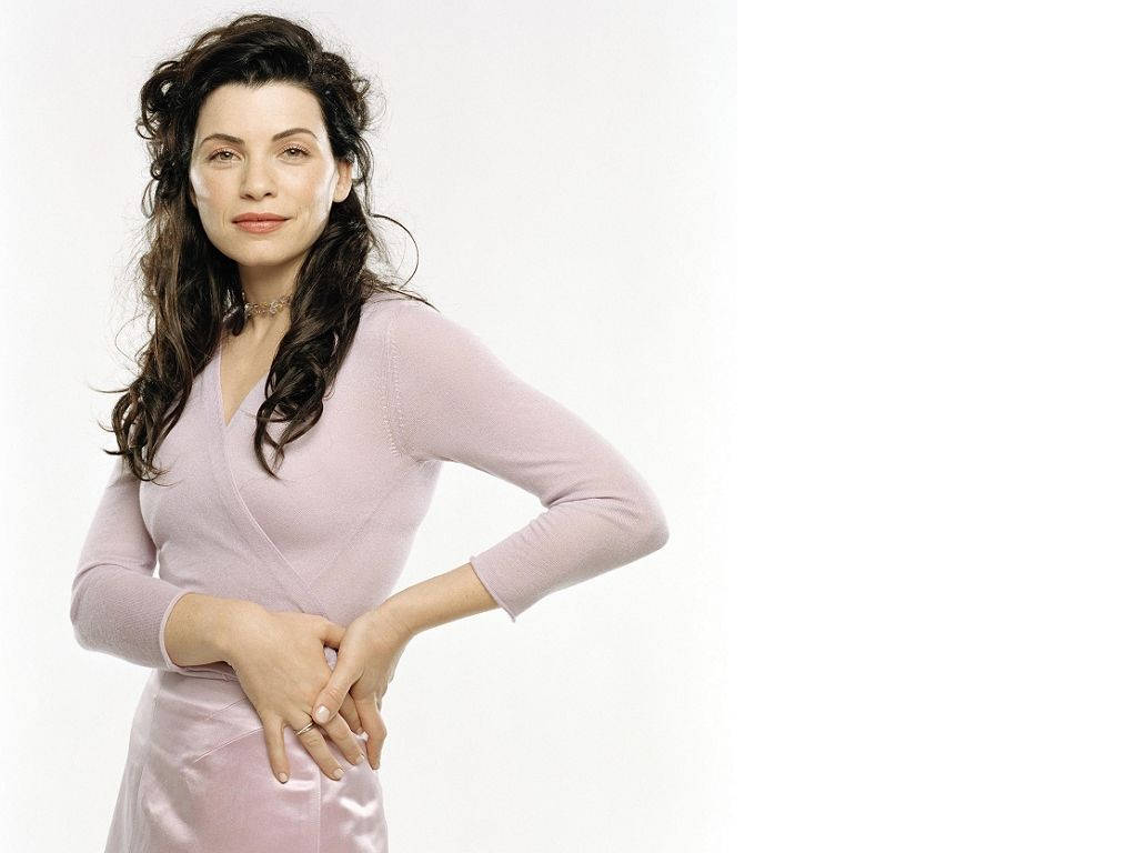 Celebrity 桌布 壁紙 — 一位深色波浪髮的女性穿著柔和的粉紅色連衣裙，自信地站在純白色背景前。