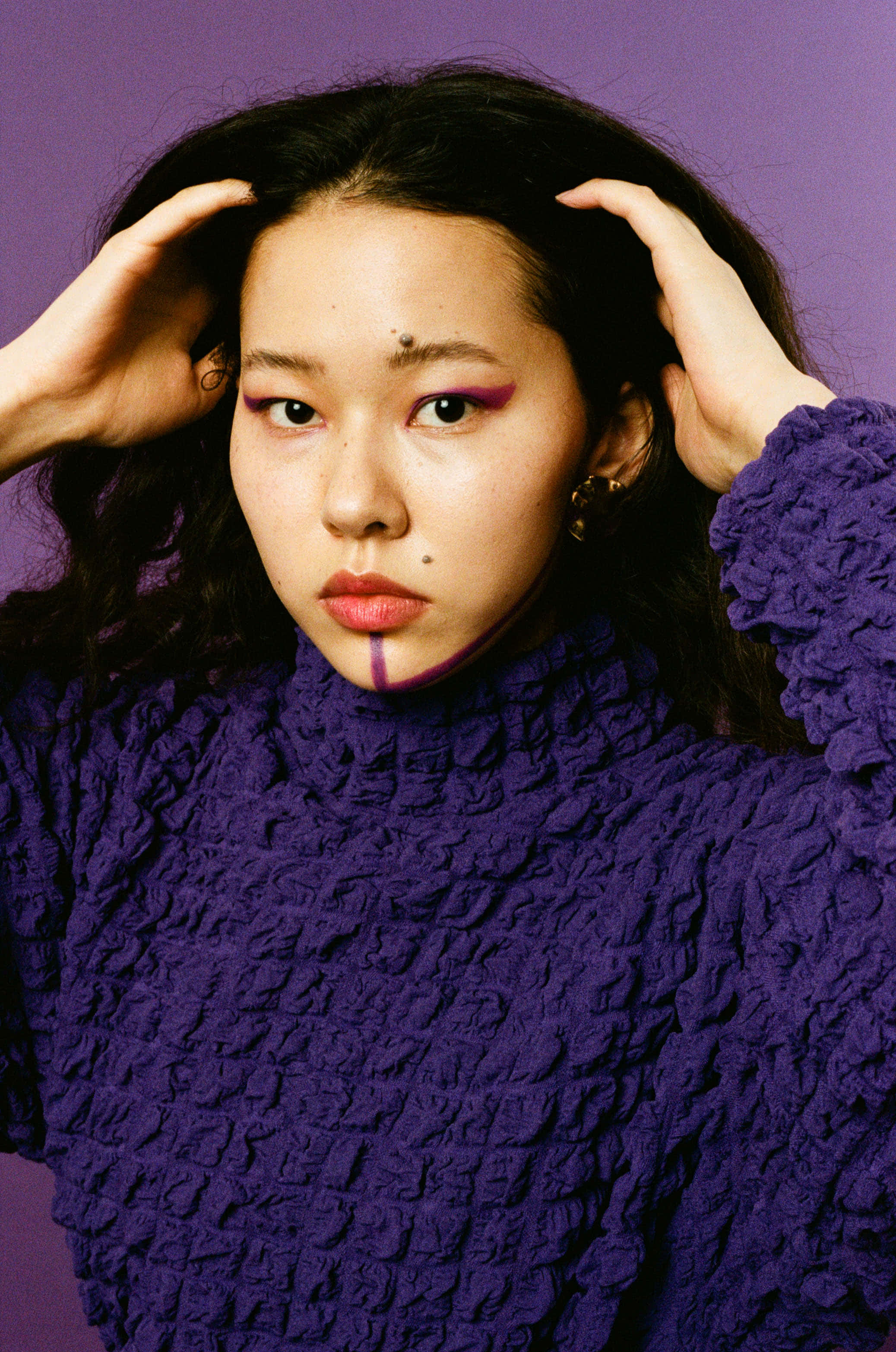 Purple Turtle-neck Sweater 桌布 壁紙 — 一位深色頭髮、化著大膽紫色妝容的女性，穿著質感紫色毛衣，在純紫色背景下凝視著。