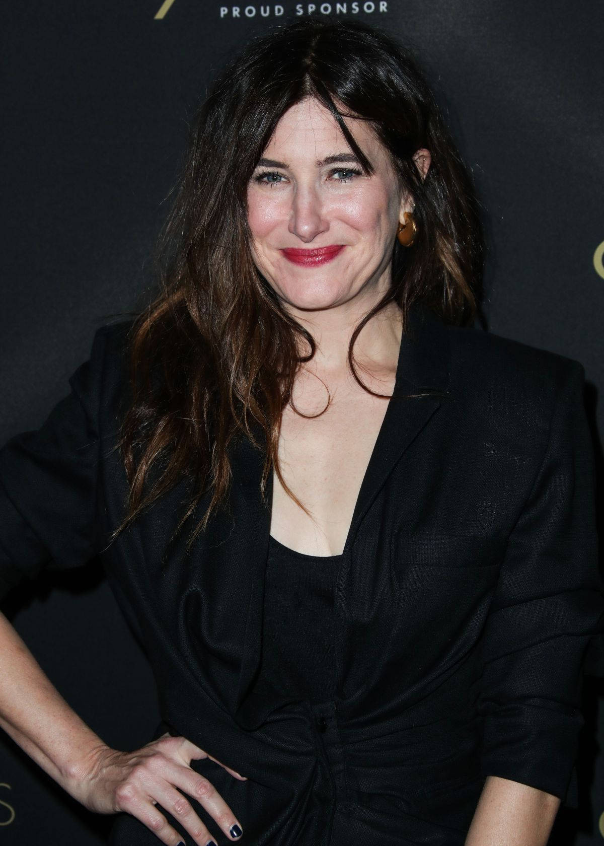 Celebrity 桌布 壁紙 — 一位深色頭髮、塗著紅色唇膏的女性，在活動中穿著黑色西裝外套溫暖地微笑。