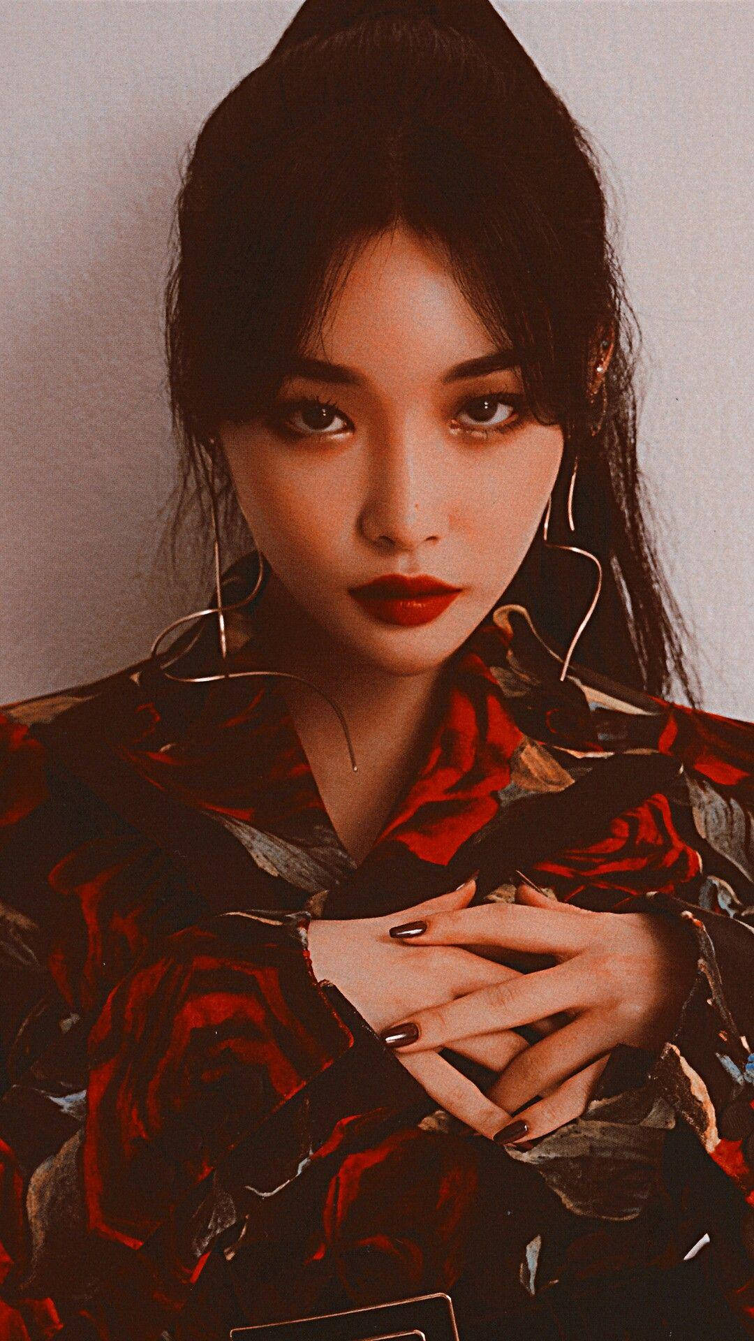 Chungha 桌布 壁紙 — 一位深色頭髮、大膽紅唇的女性，在純色背景前穿著玫瑰圖案上衣。