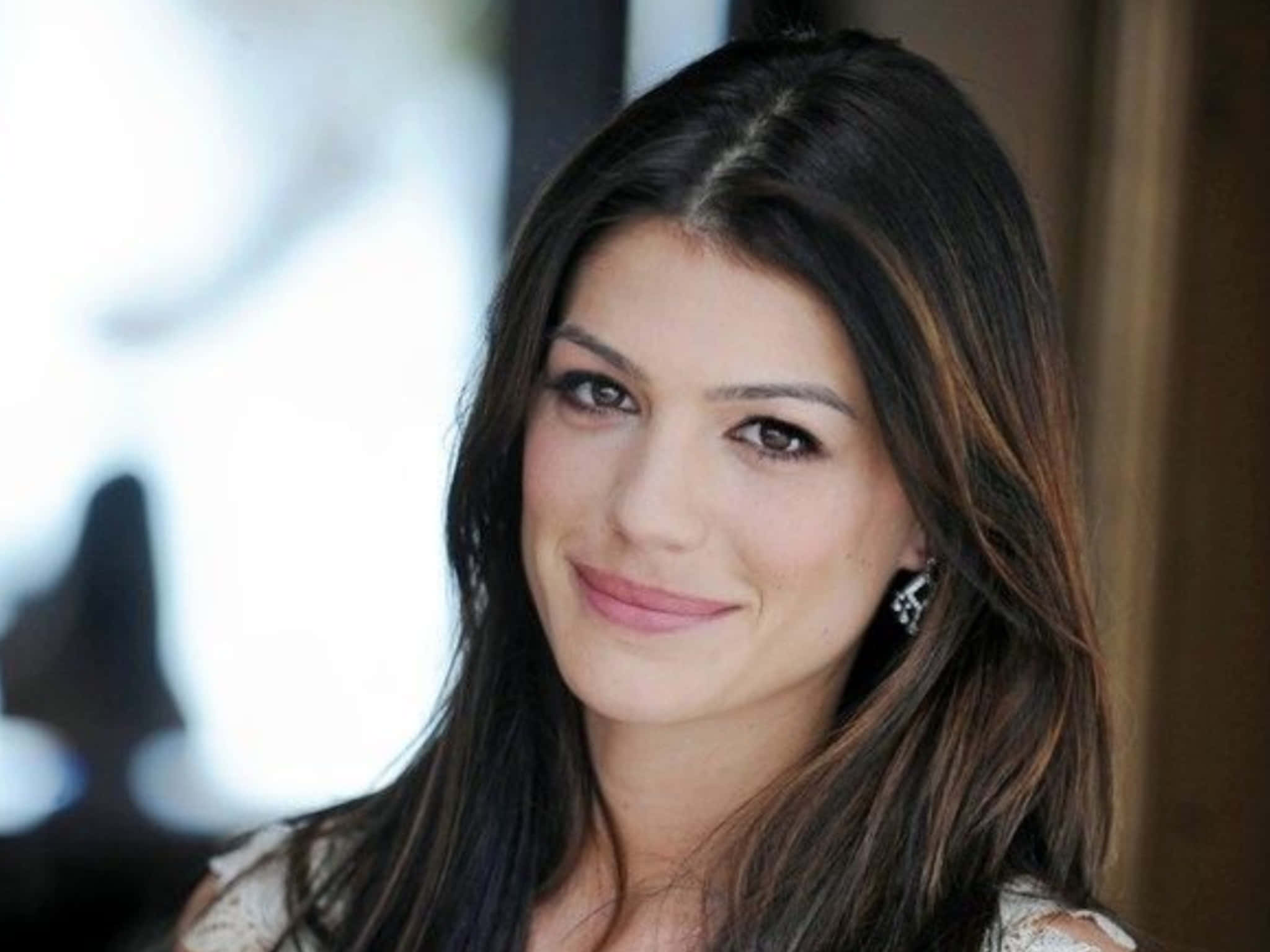 Genevieve Padalecki 桌布 壁紙 — 一位深色頭髮、帶著溫柔微笑的女性特寫肖像，直視鏡頭。