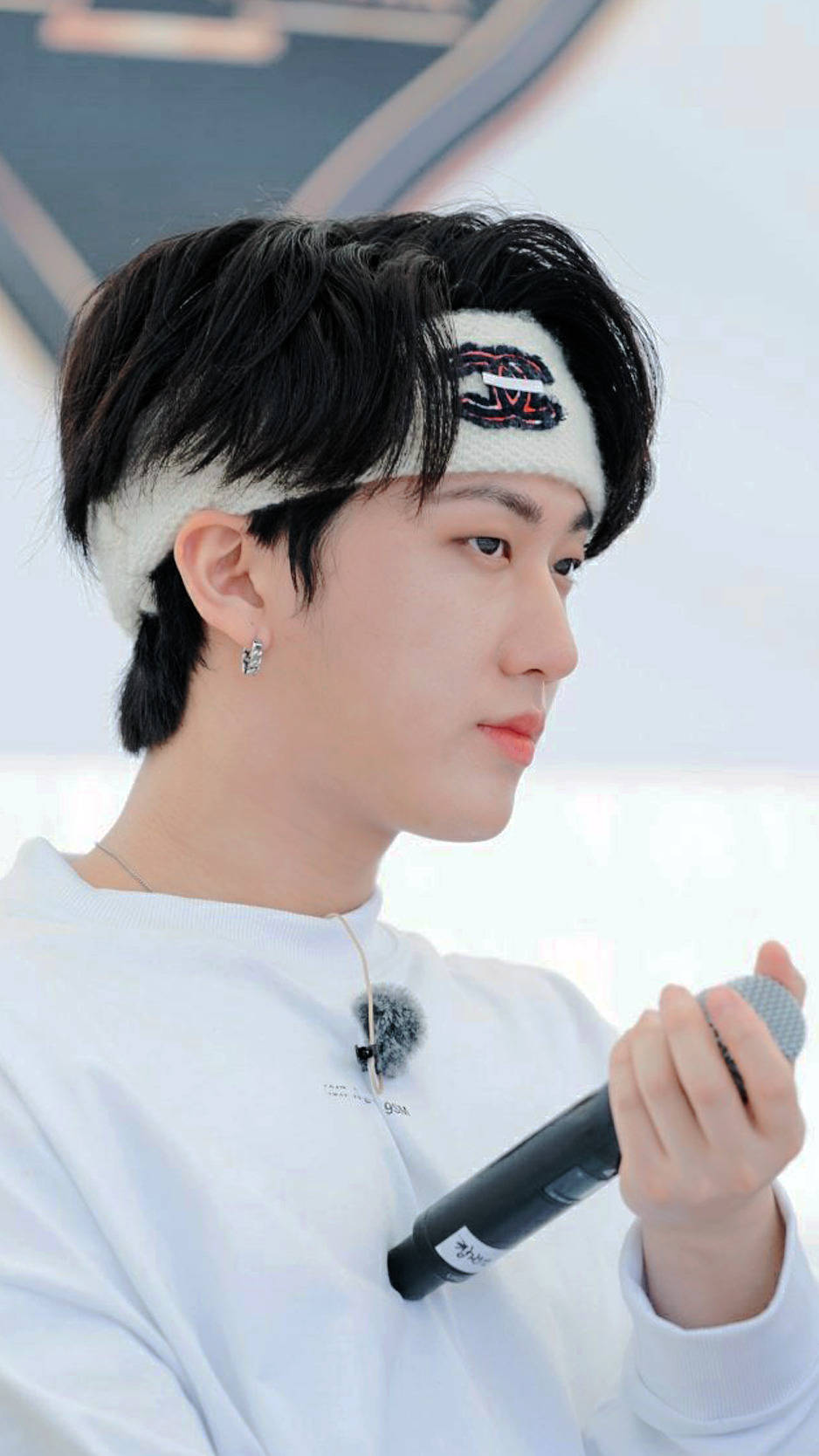 Changbin 桌布 壁紙 — 一位深色頭髮、戴白色頭帶的年輕男子，在明亮的環境中手持麥克風，視線望向一旁。