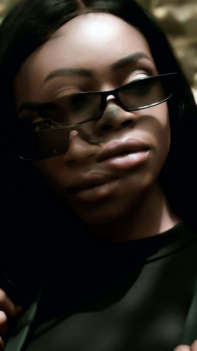 Nigeria 桌布 壁紙 — 一位深色頭髮、戴眼鏡的女子的特寫肖像，在陰影背景上以戲劇性的燈光照明。