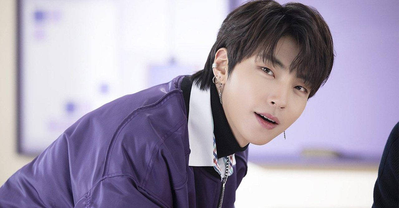 Hwang In Yeop 桌布 壁紙 — 一位深色頭髮、戴著多個耳環的年輕男子向前傾，身穿閃亮的紫色外套，背景柔和模糊。