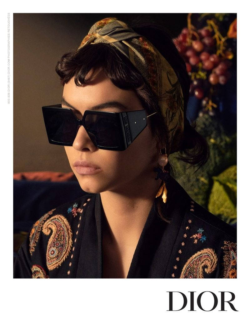 一位時尚女性，戴著大太陽眼鏡和圖案頭巾，搭配刺繡外套。 — Dior 動態 壁紙