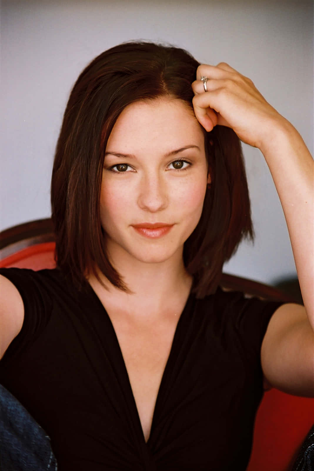 Chyler Leigh 桌布 壁紙 — 一位深色頭髮、戴著戒指的女性輕輕觸碰太陽穴，同時直視相機。