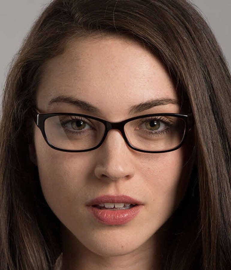 glasses 桌布 壁紙 — 一位深色頭髮、戴黑色眼鏡的女性近距離肖像，面無表情地直視鏡頭。