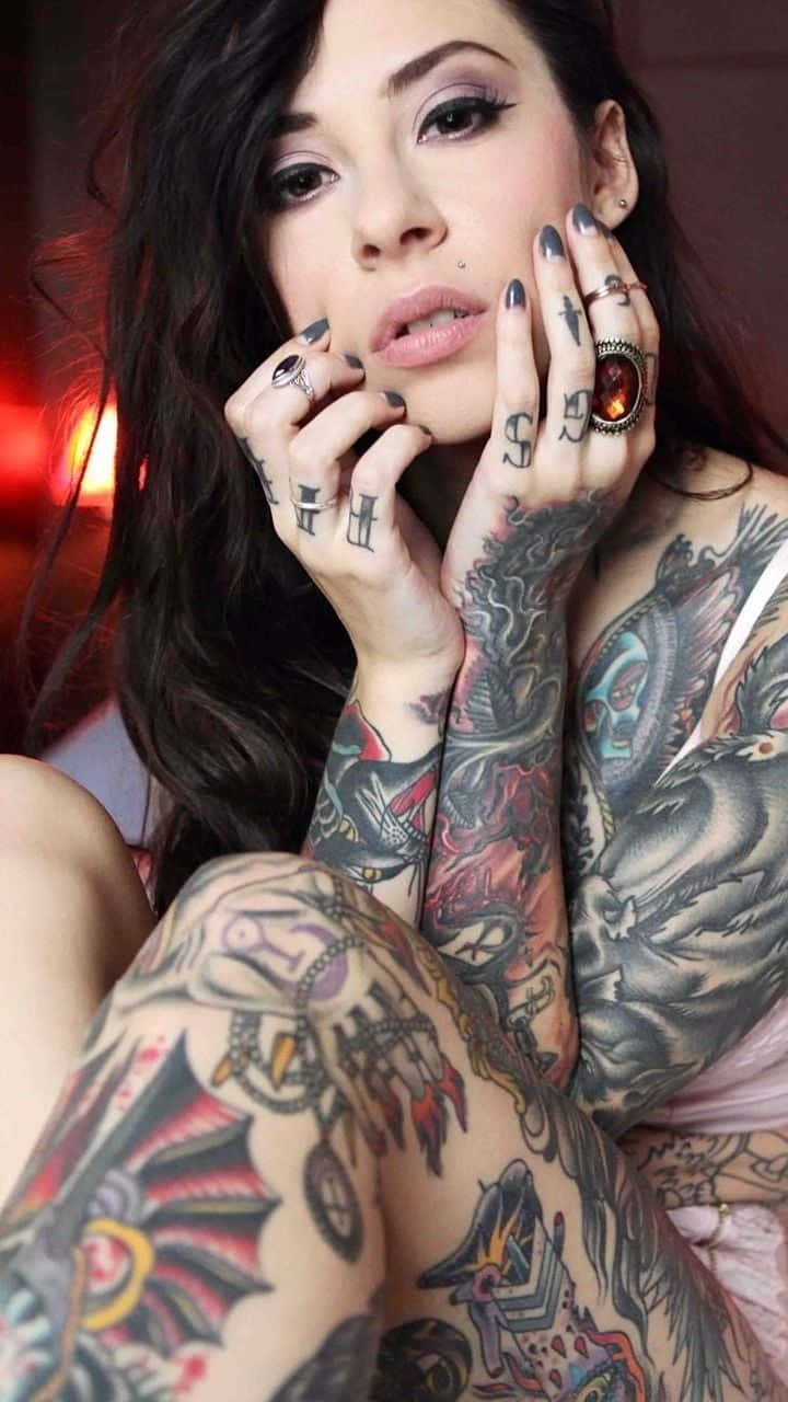 Tattoo 桌布 壁紙 — 一位深色頭髮、濃妝豔抹的女性，在溫暖模糊的背景前，擺出帶有紋身的手臂和戴著戒指的雙手姿勢。