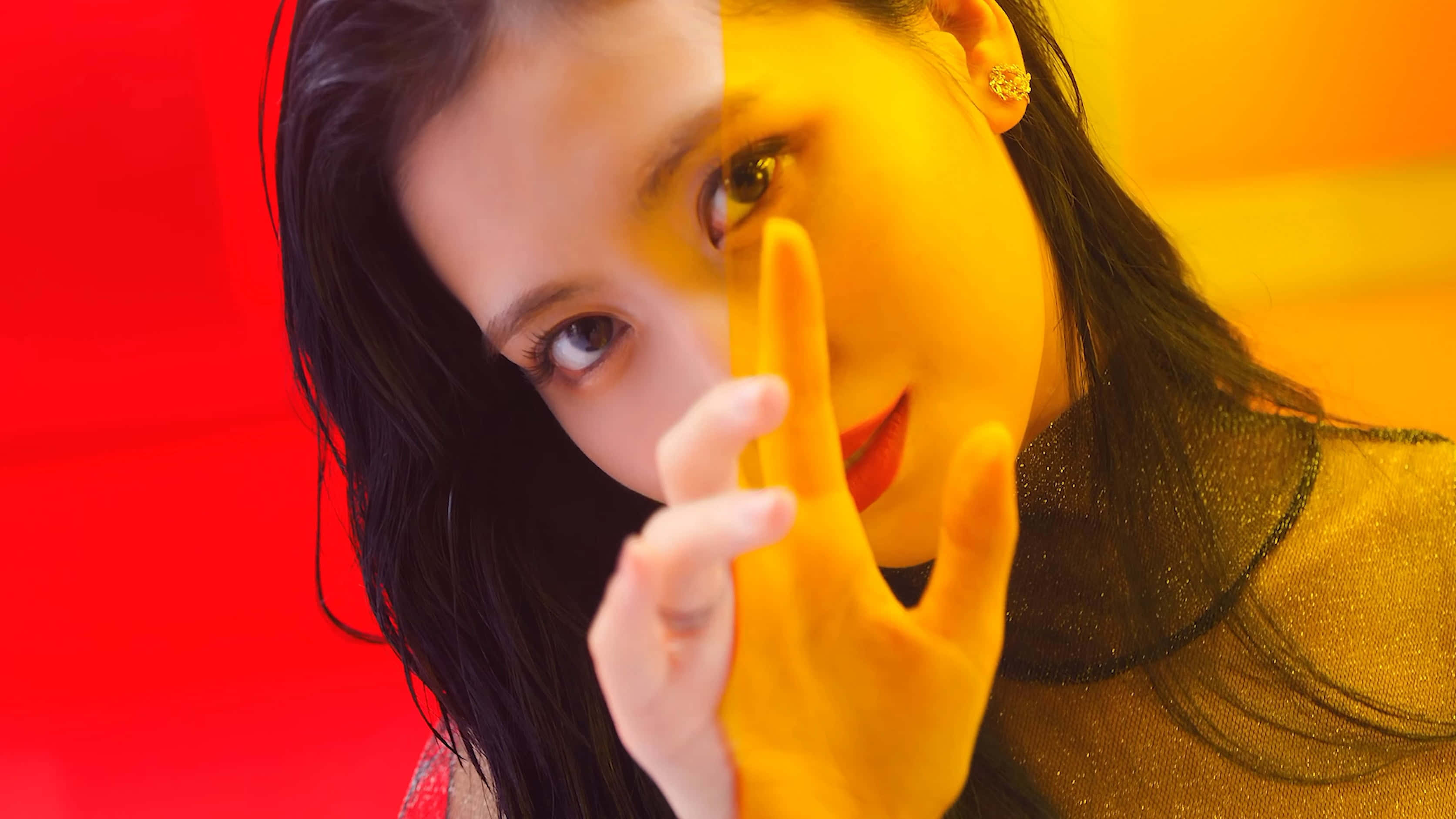 twice 桌布 壁紙 — 一位深色頭髮、紅唇的女性，在紅黃分半的背景前，將手靠近臉部擺姿勢。
