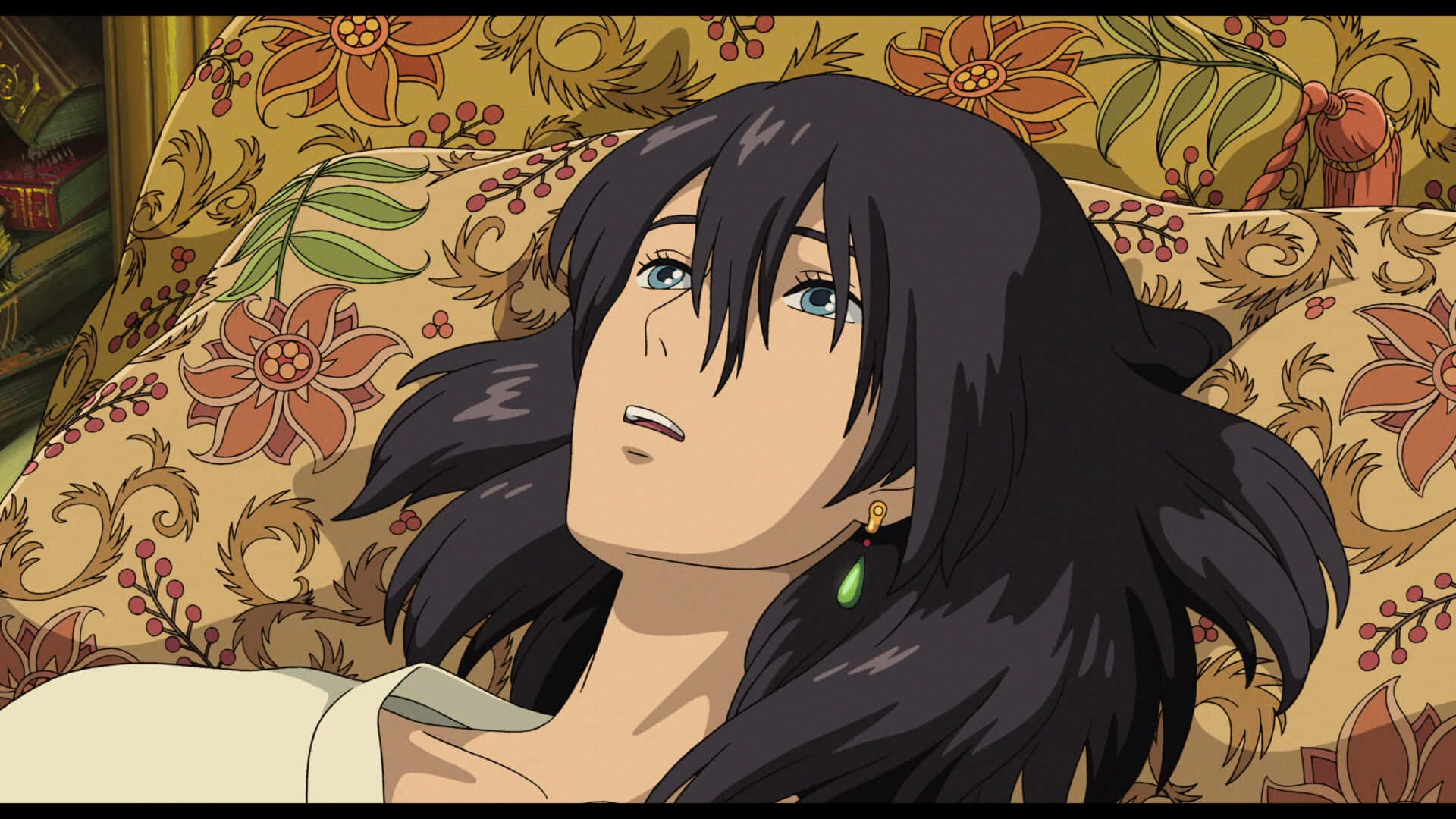Howl's Moving Castle 桌布 壁紙 — 一位深色頭髮、藍眼睛的年輕女性在溫暖的房間裡將頭靠在花卉圖案的靠墊上。
