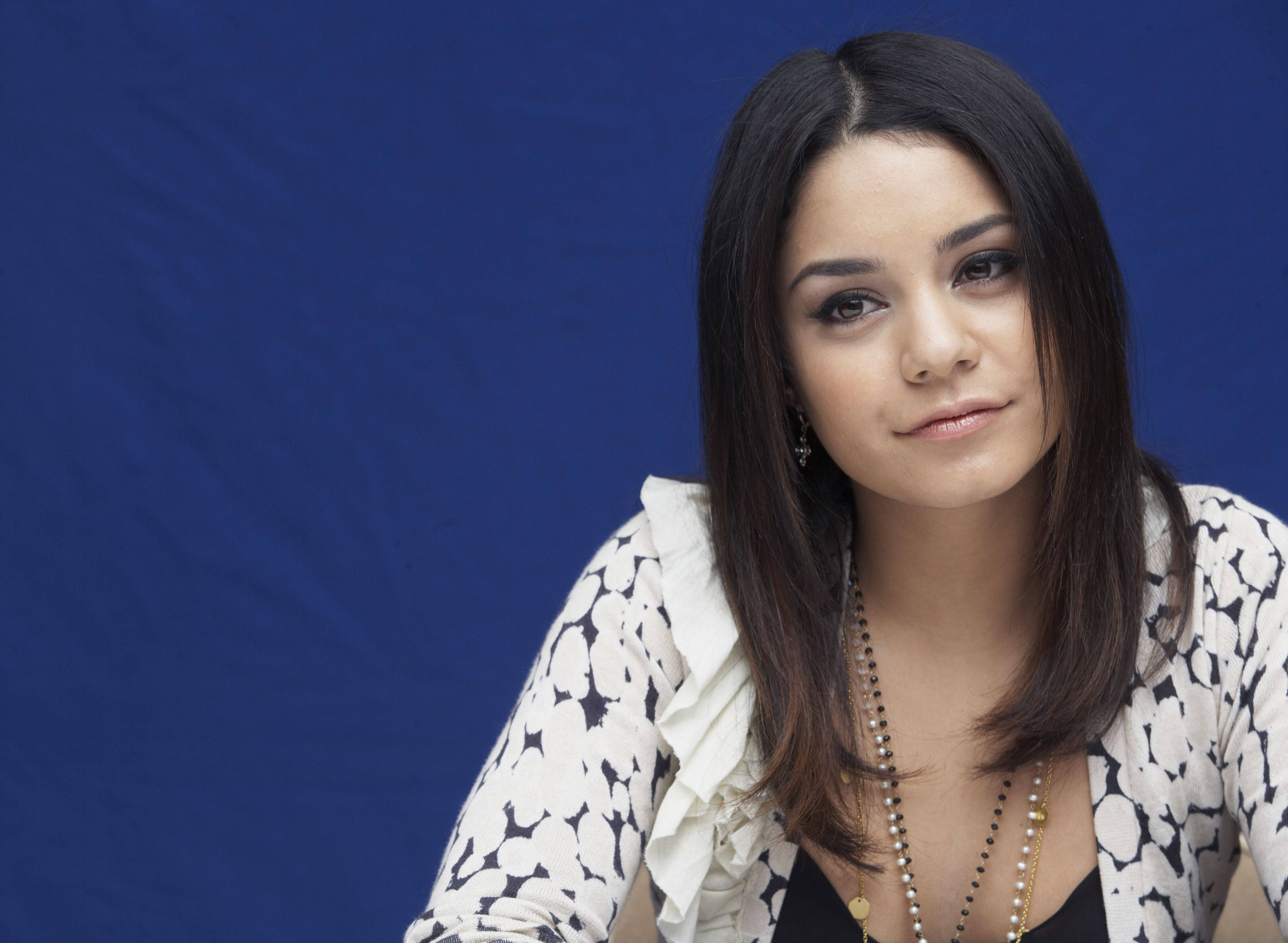 Vanessa Hudgens 桌布 壁紙 — 一位深色頭髮、身穿圖案襯衫的女性，在純藍色背景下溫柔凝視。
