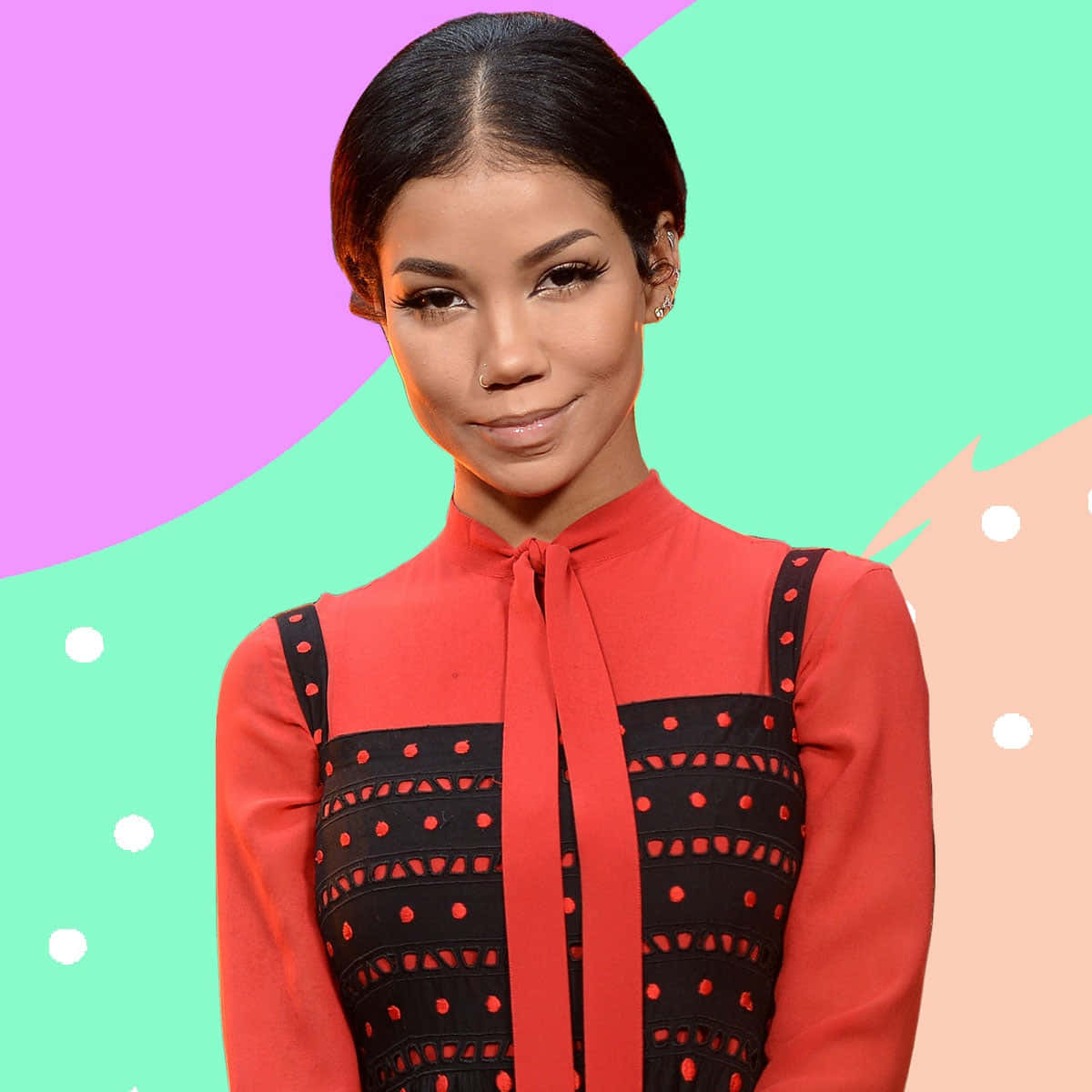 jhene aiko 桌布 壁紙 — 一位深色頭髮、身穿紅色襯衫的女性，站在充滿幾何圖案和白色圓點的鮮豔粉彩背景前。