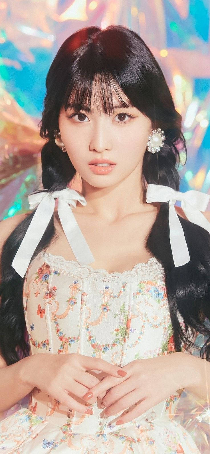 Momo 桌布 壁紙 — 一位深色頭髮、身穿花卉連衣裙的年輕女性，在充滿活力的全息背景前溫柔凝視。