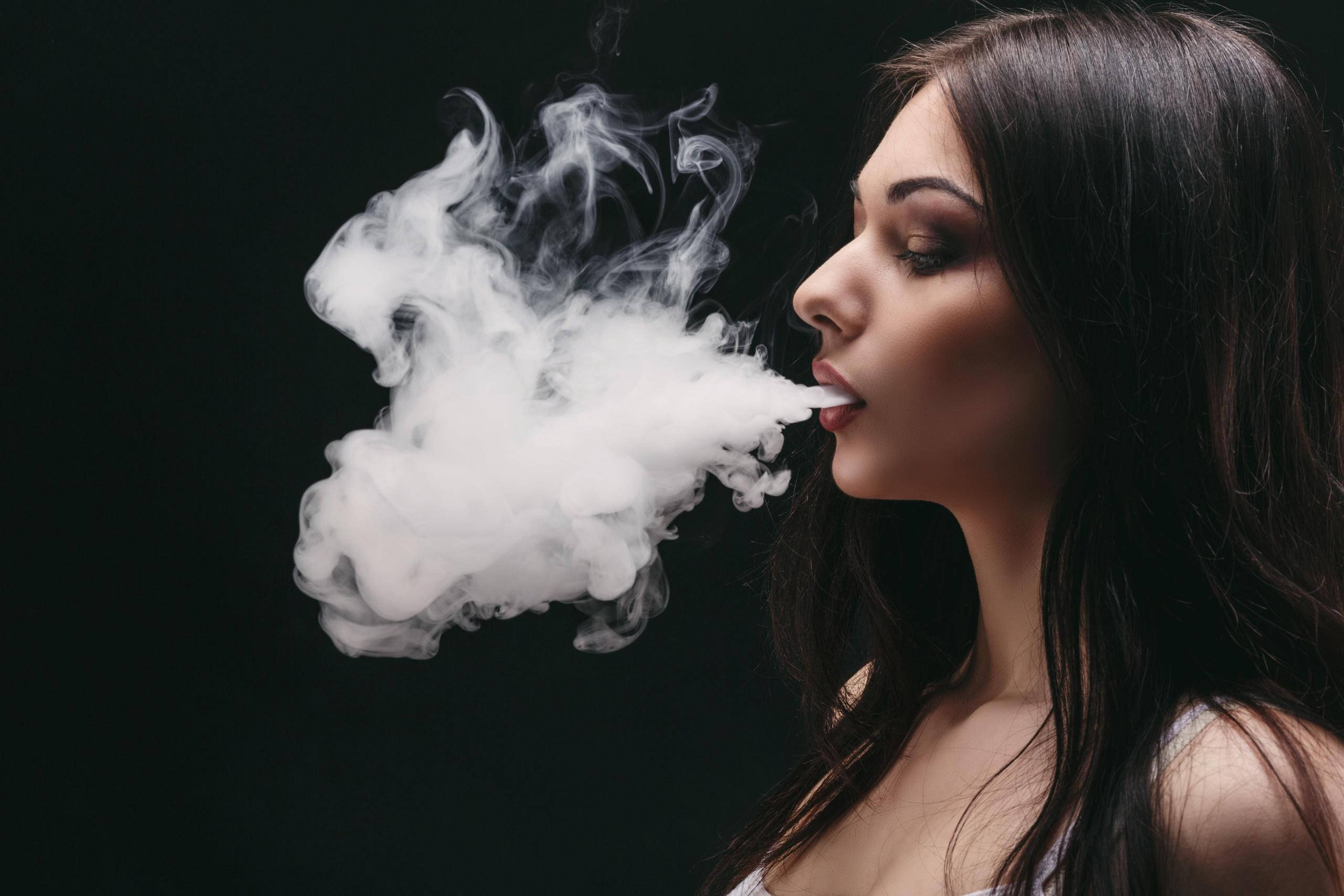 girls 桌布 壁紙 — 一位深色頭髮的女性在純黑背景上呼出一團濃厚的蒸氣雲。