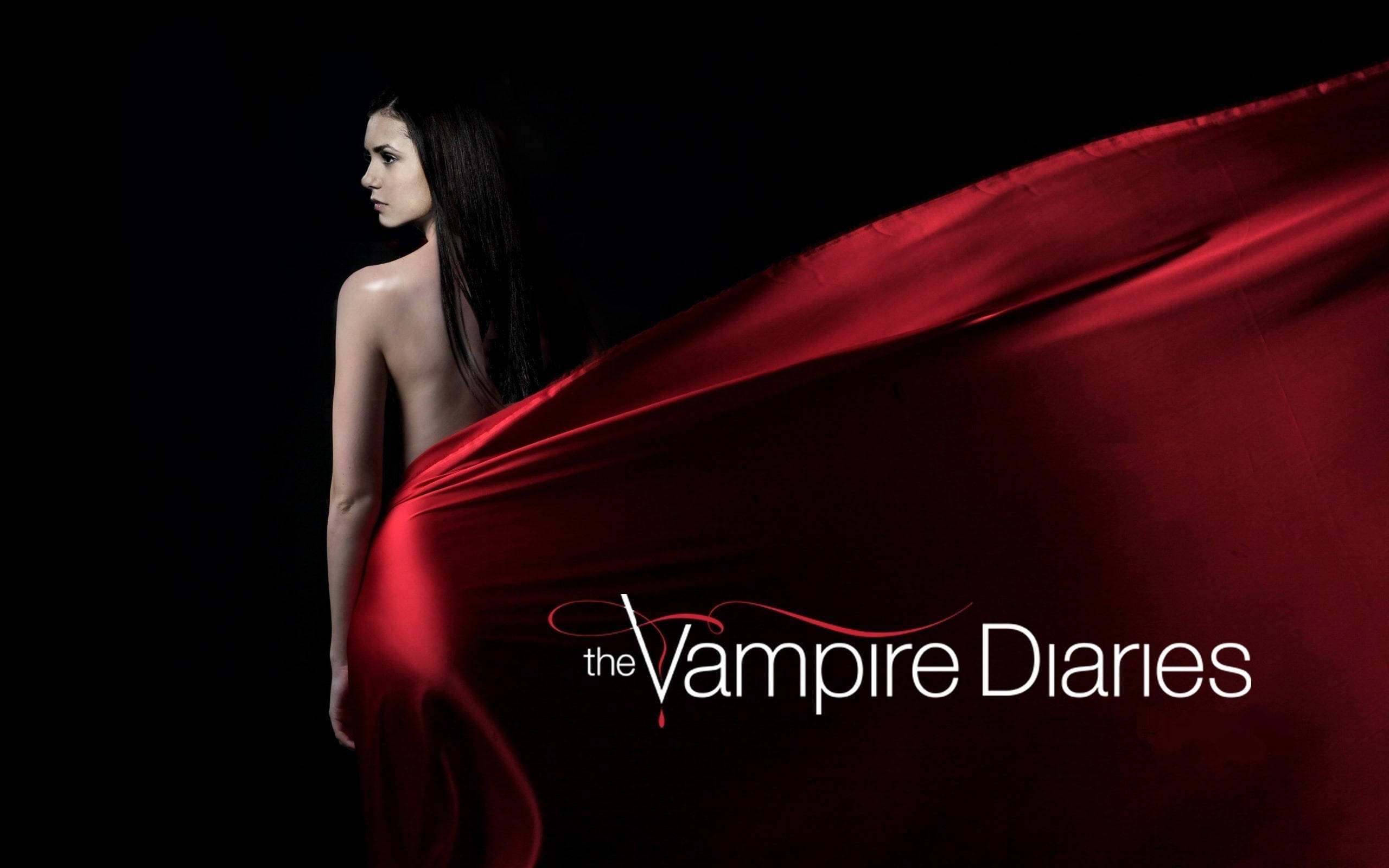 Vampire Diaries 桌布 壁紙 — 一位深色頭髮的女性站在陰影中，披著飄逸的紅色布料，背景為黑色，並帶有標題《The Vampire Diaries》。