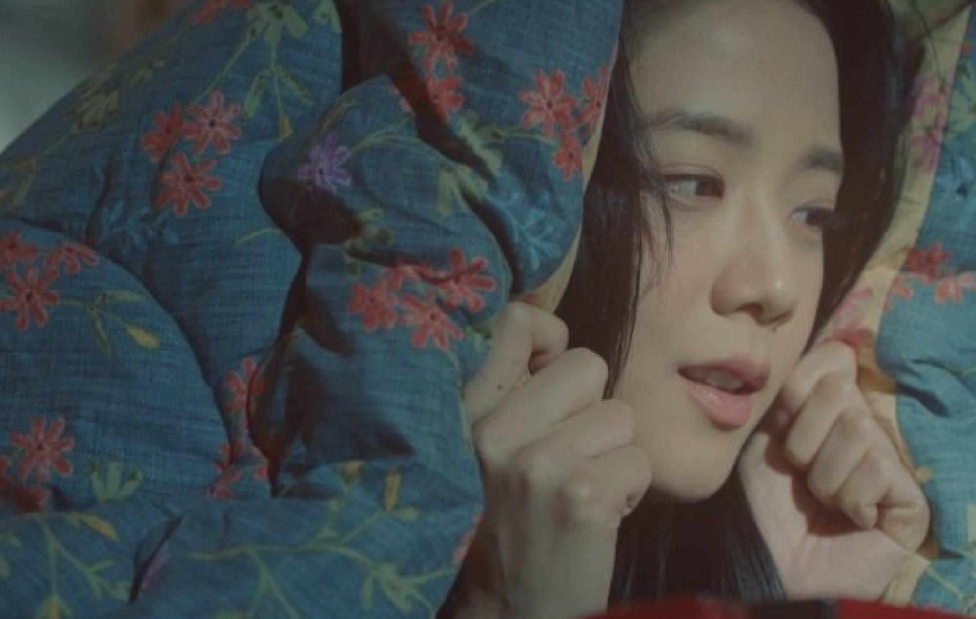 drama 桌布 壁紙 — 一位深色頭髮的年輕女子從藍色花卉被褥下探出頭來，雙手抓著靠近臉部的布料。