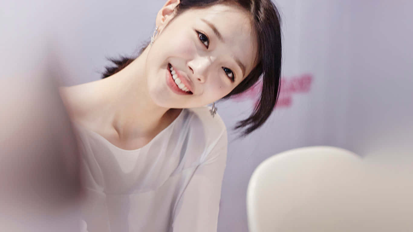 smiling 桌布 壁紙 — 一位深色頭髮的年輕女性在柔和光線的室內環境中微笑著向前傾。
