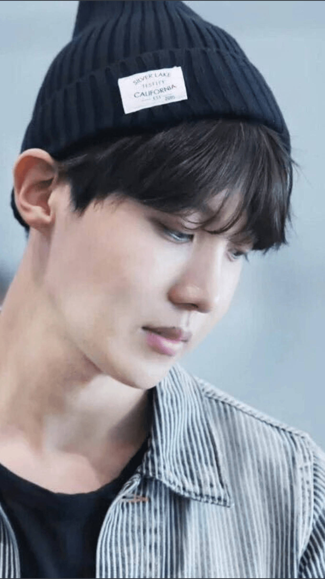 jhope 桌布 壁紙 — 一位深色頭髮的年輕男子戴著黑色羅紋毛帽，身穿條紋襯衫，背景是柔和的灰色。