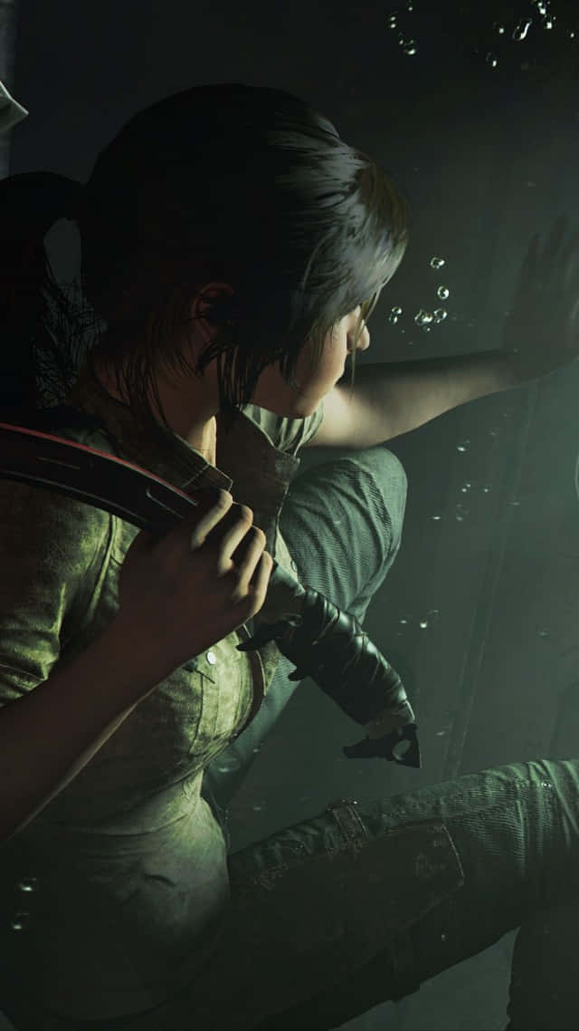 Pixel 3 Shadow Of The Tomb Raider 桌布 壁紙 — 一位深色頭髮紮成馬尾的女性在水中游泳，手持一把刀，在昏暗的綠色光線中，周圍有氣泡升起。