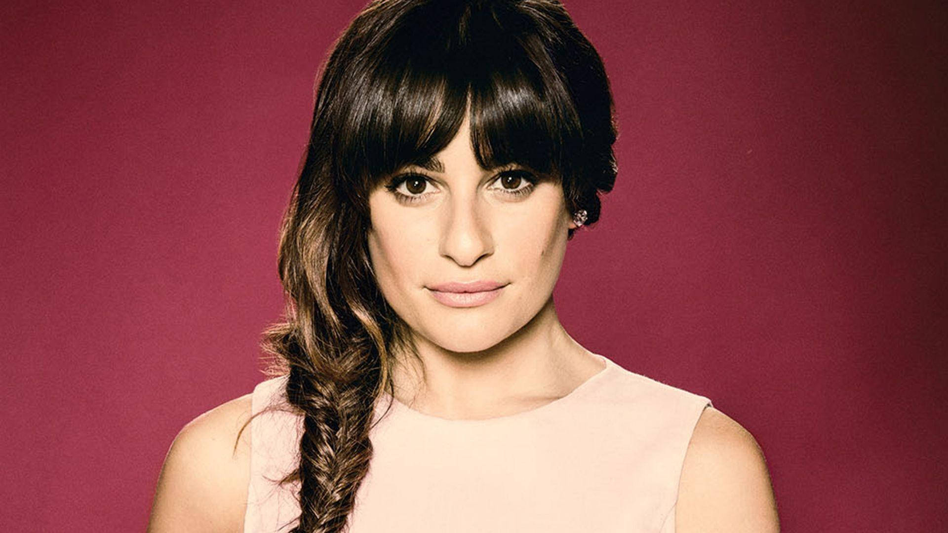 Lea Michele 桌布 壁紙 — 一位深色頭髮編成辮子的女性，在純栗色背景下直視鏡頭。