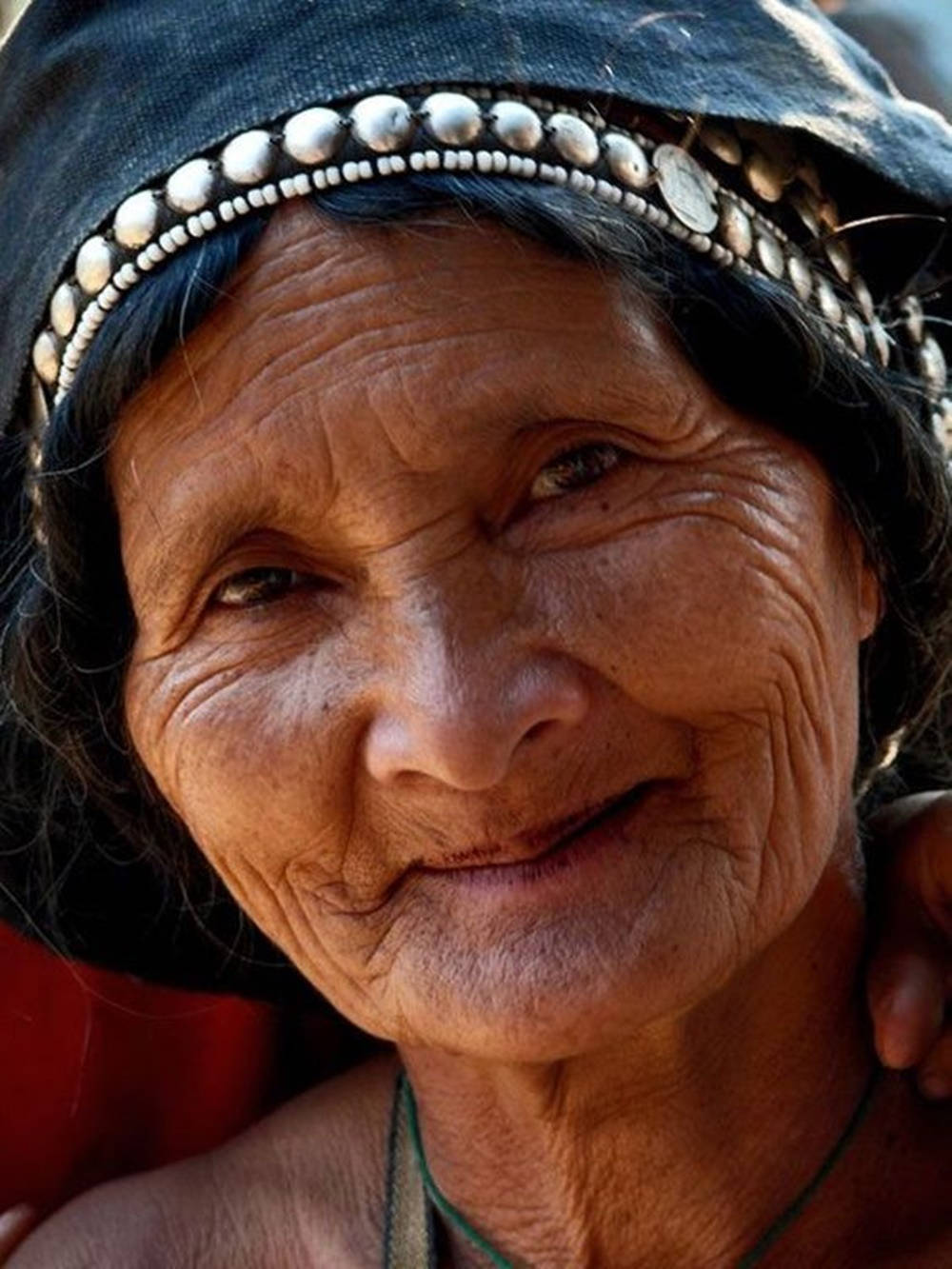 Woman 桌布 壁紙 — 一位滿臉皺紋的老婦人戴著珠飾頭帶，溫暖微笑的特寫肖像。