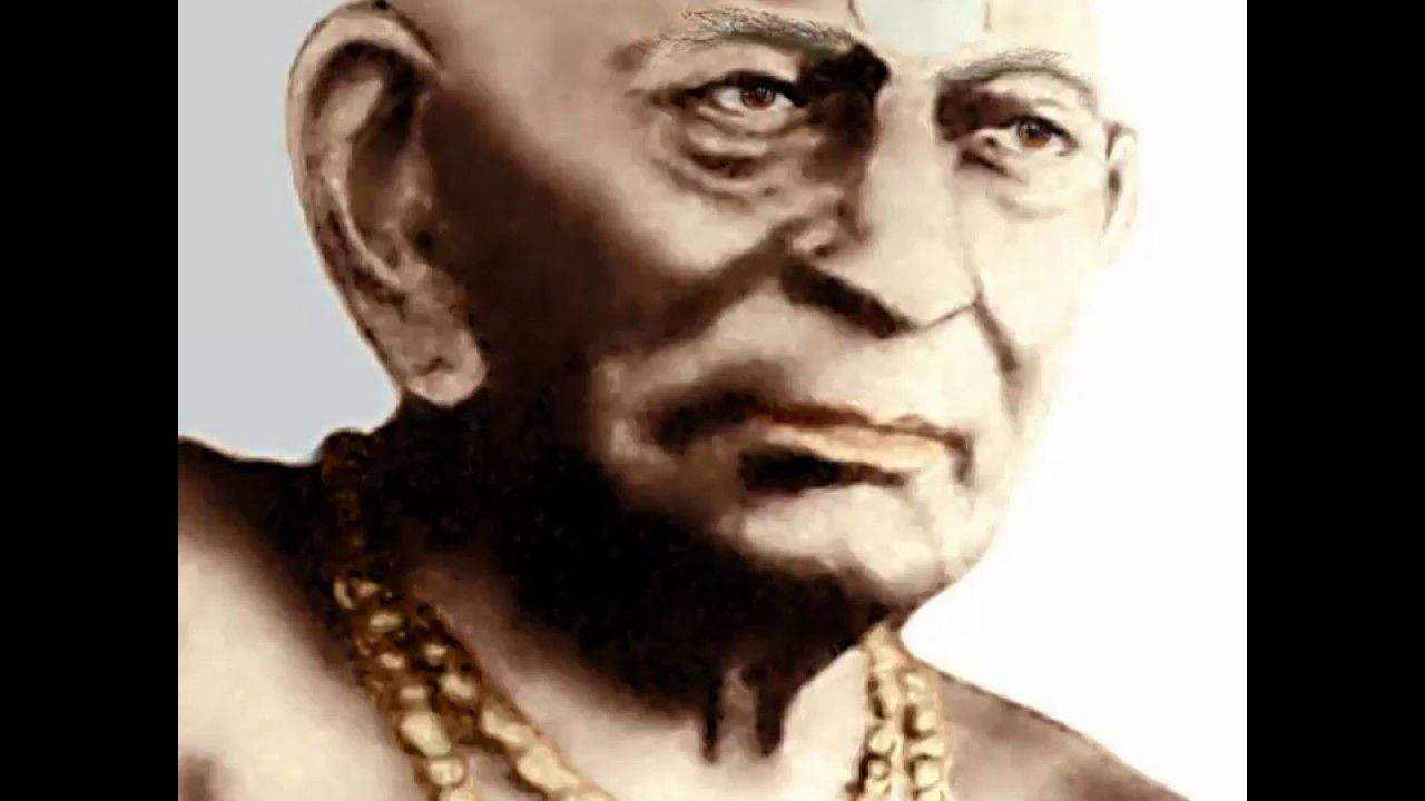 shri swami samarth 桌布 壁紙 — 一位滿臉皺紋的長者戴著珠鏈，在素色背景前的特寫肖像。