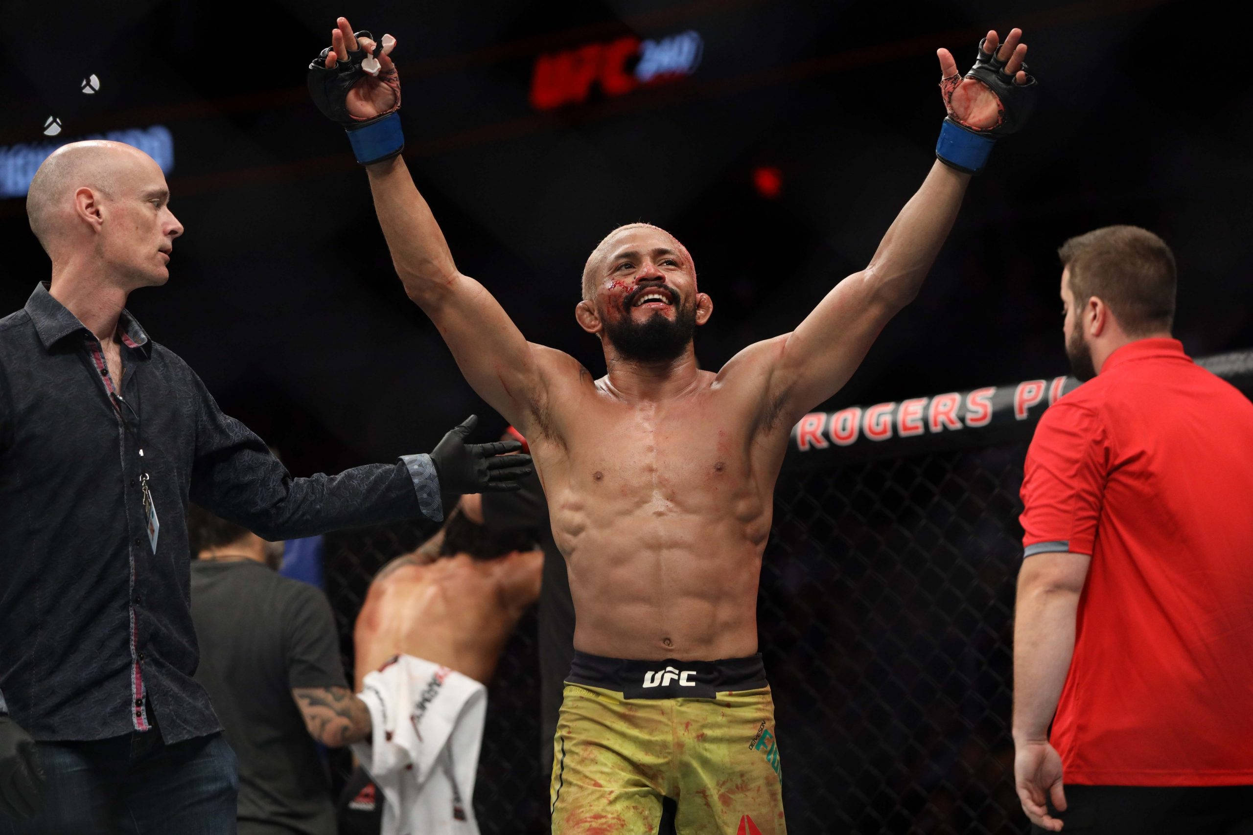 Victory 桌布 壁紙 — 一位滿臉鮮血、高舉雙臂的UFC勝利拳手，在明亮的場館燈光下於八角籠內慶祝。