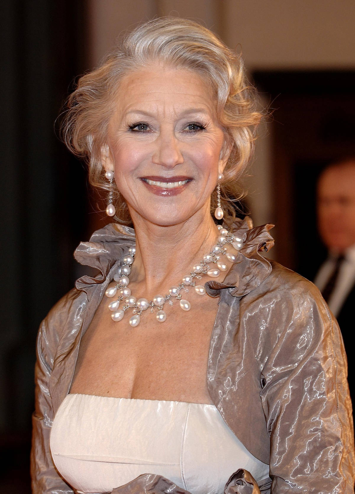 Celebrity 桌布 壁紙 — 一位滿頭銀髮、容光煥發的長者女性，戴著珍珠項鍊和相配的耳環，露出溫暖的笑容。