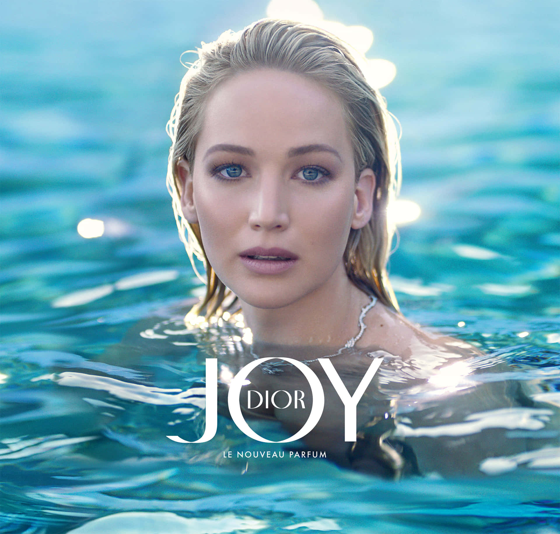 Dior 動態 桌布 壁紙 — 一位濕金髮藍眼的女士在明亮的陽光下，從藍綠色的泳池水中平靜地凝視。