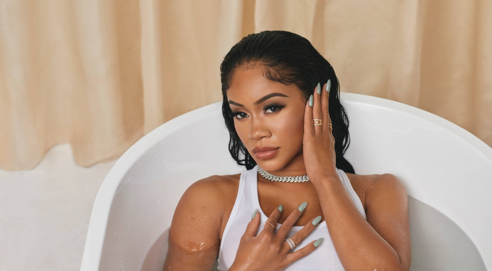 Saweetie 桌布 壁紙 — 一位濕髮、綠色指甲的女性坐在白色浴缸中，身穿白色上衣和鑽石頸鍊。