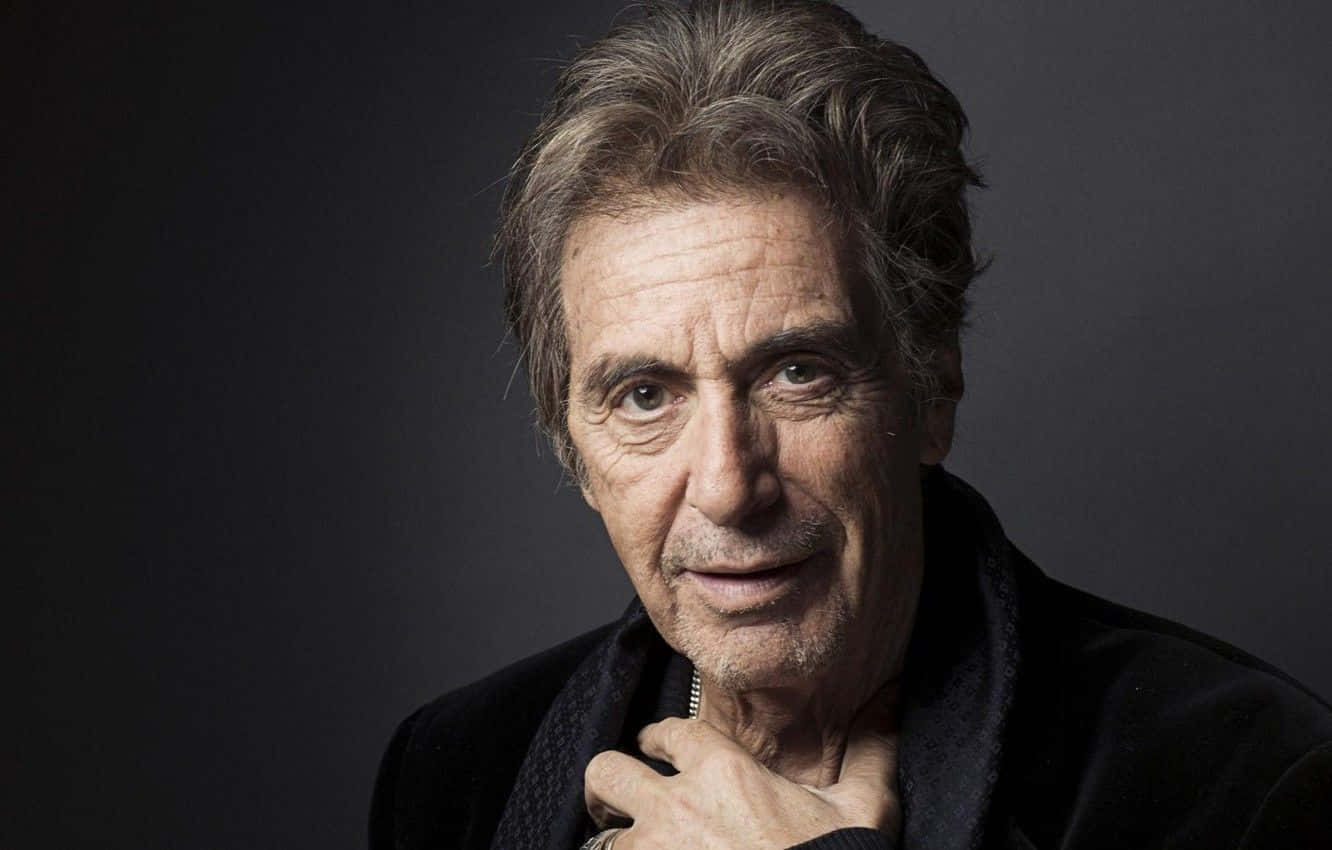 Al Pacino 桌布 壁紙 — 一位灰白頭髮、眼神銳利的年長男士的頭像特寫，身穿深色外套，背景為柔和的灰色。