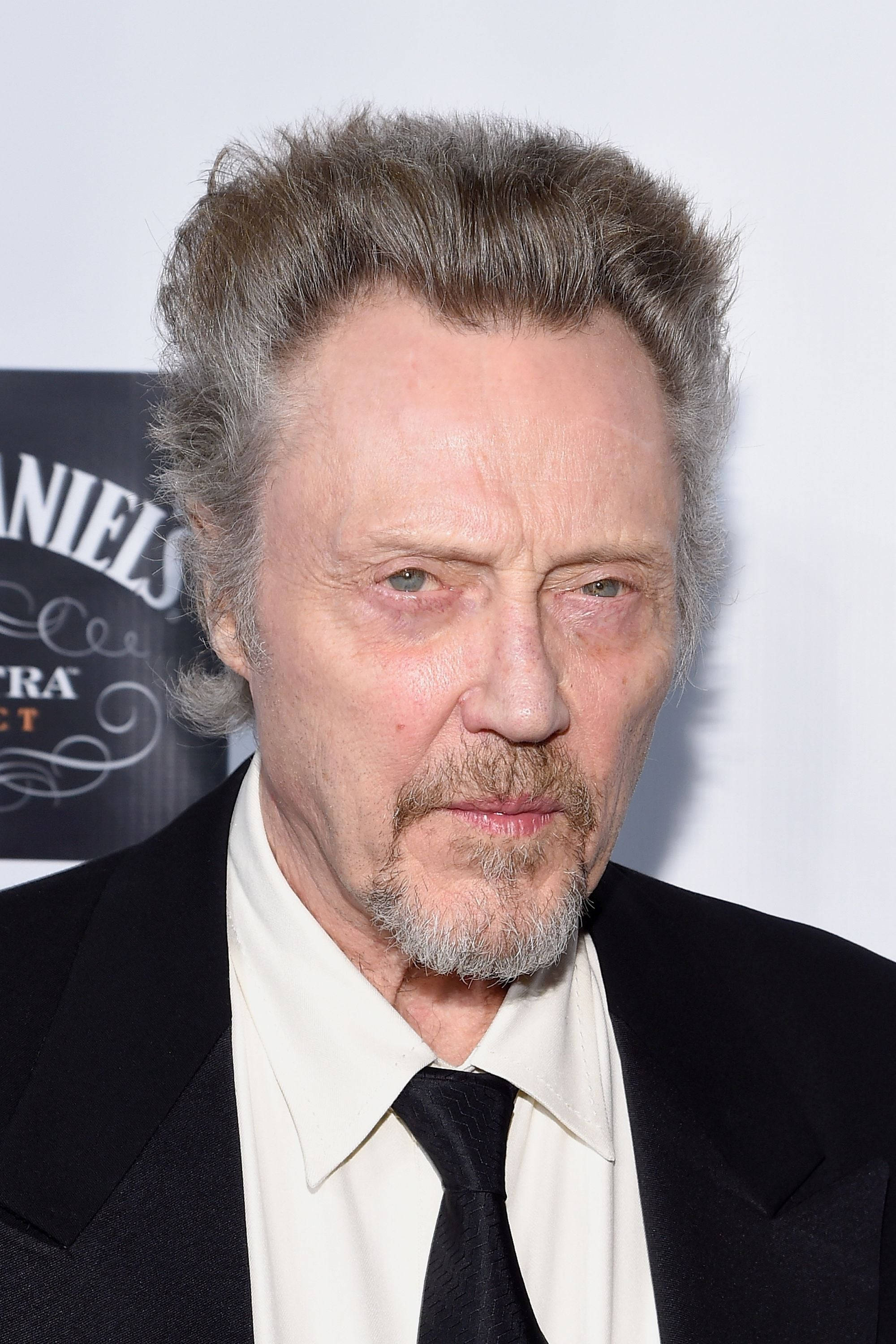 Celebrity 桌布 壁紙 — 一位灰白頭髮和鬍鬚的年長男士穿著黑色西裝和領帶，在白色背景前的特寫肖像。