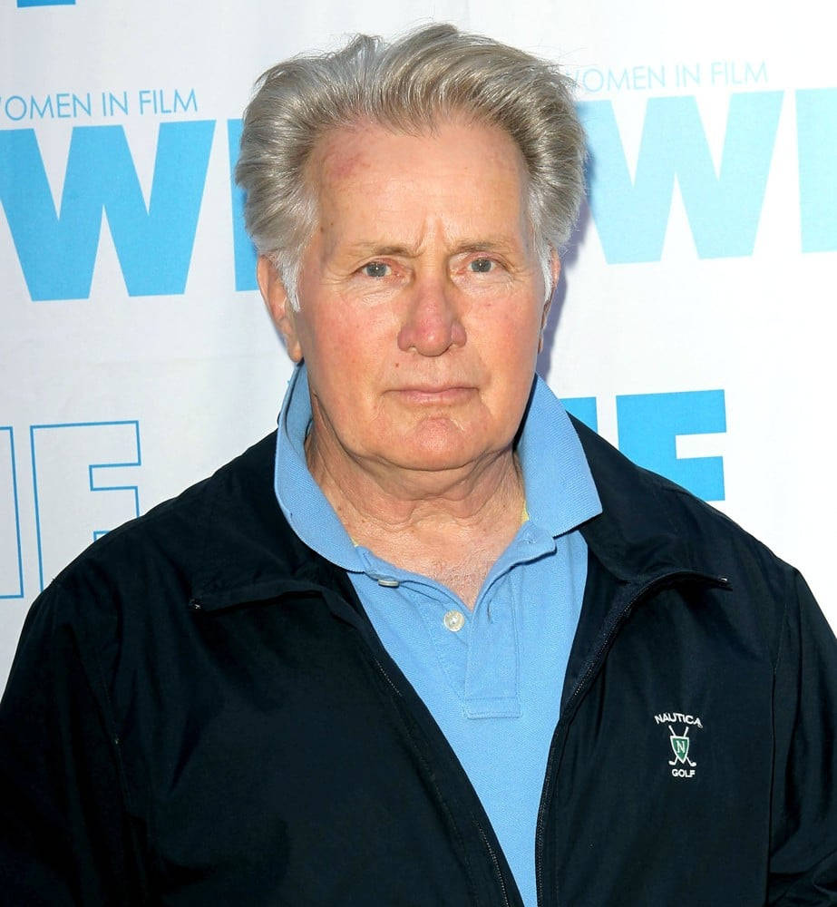 Celebrity 桌布 壁紙 — 一位灰白頭髮的年長男士在Women in Film活動中，身穿黑色Nautica高爾夫外套，內搭藍色Polo衫。