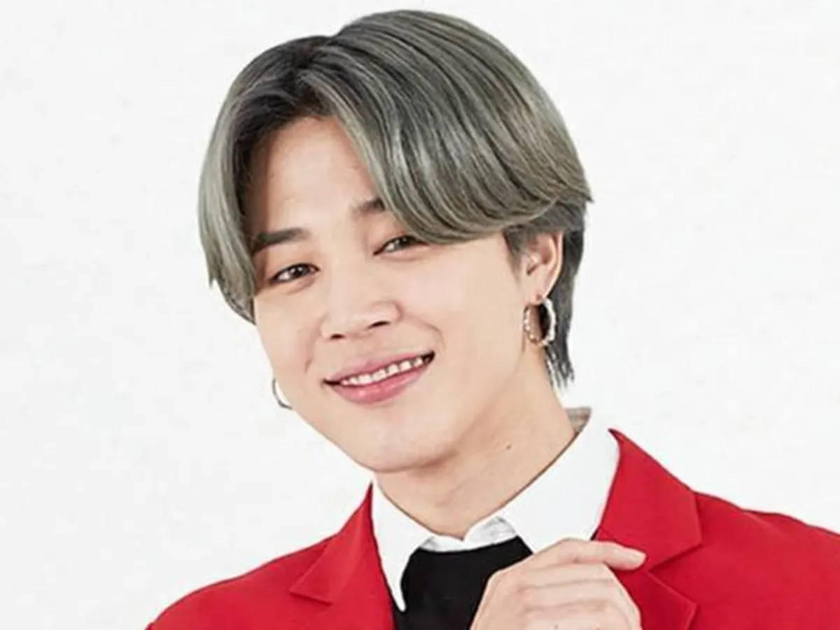BTS 智旻 桌布 壁紙 — 一位灰髮、戴著圈狀耳環的年輕男子面帶微笑，身穿大膽的紅色西裝外套，背景是純白色。