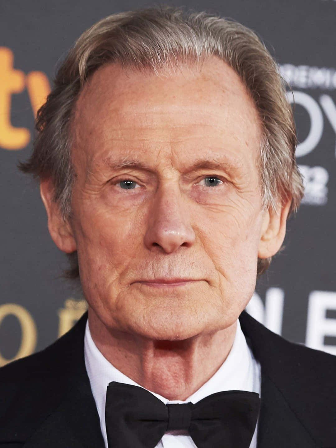 actor 桌布 壁紙 — 一位灰髮、穿著黑色燕尾服和領結的尊貴年長男士在正式活動中的特寫肖像。