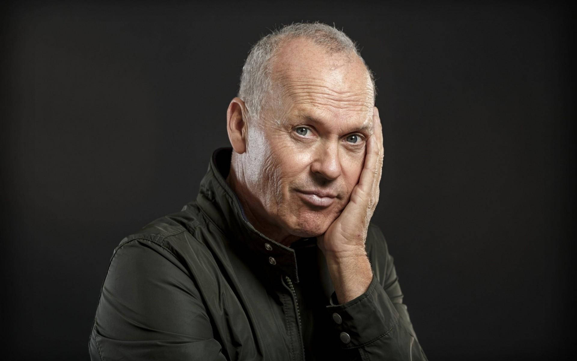 Celebrity 桌布 壁紙 — 一位灰髮中年男子在深色背景下將下巴擱在手上，專注地凝視相機。