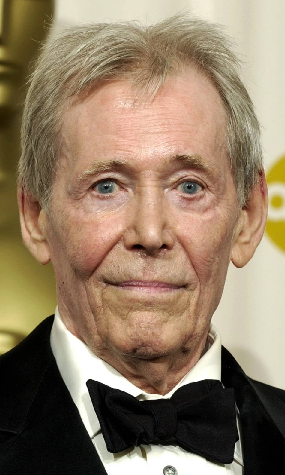 oscars 桌布 壁紙 — 一位灰髮藍眼的老年男士在正式場合穿著黑色燕尾服和領結的特寫肖像。