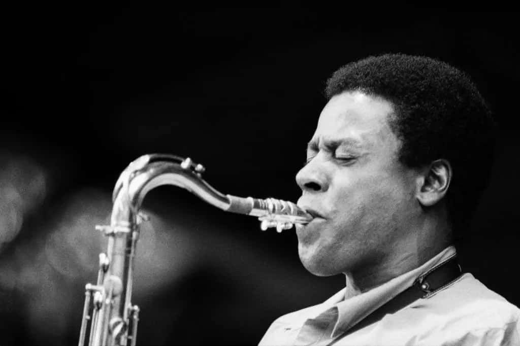 Wayne Shorter 桌布 壁紙 — 一位爵士樂手閉著眼睛，全神貫注地吹奏薩克斯風的黑白特寫。