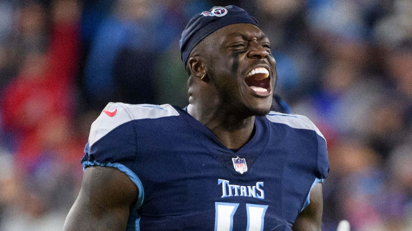 身穿泰坦隊球衣的足球員在夜間球場上大喊。 — NFL GIF 壁紙