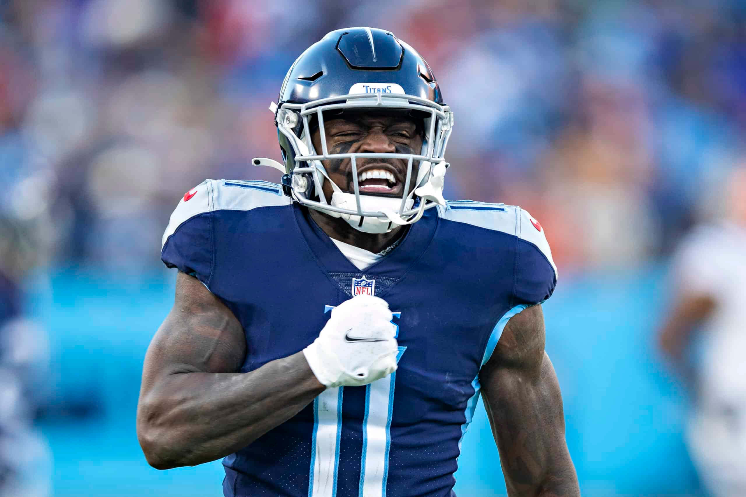 Tennessee Titans 桌布 壁紙 — 一位田納西泰坦隊的足球員穿著藍白制服在球場上勝利咆哮。
