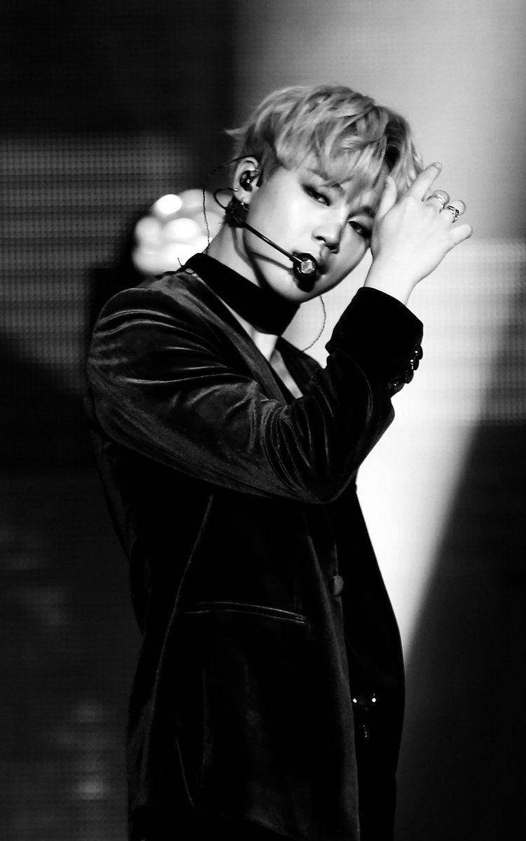 BTS 黑色 桌布 壁紙 — 一位男表演者在舞台上單手整理頭髮，戴著麥克風耳機的黑白肖像。